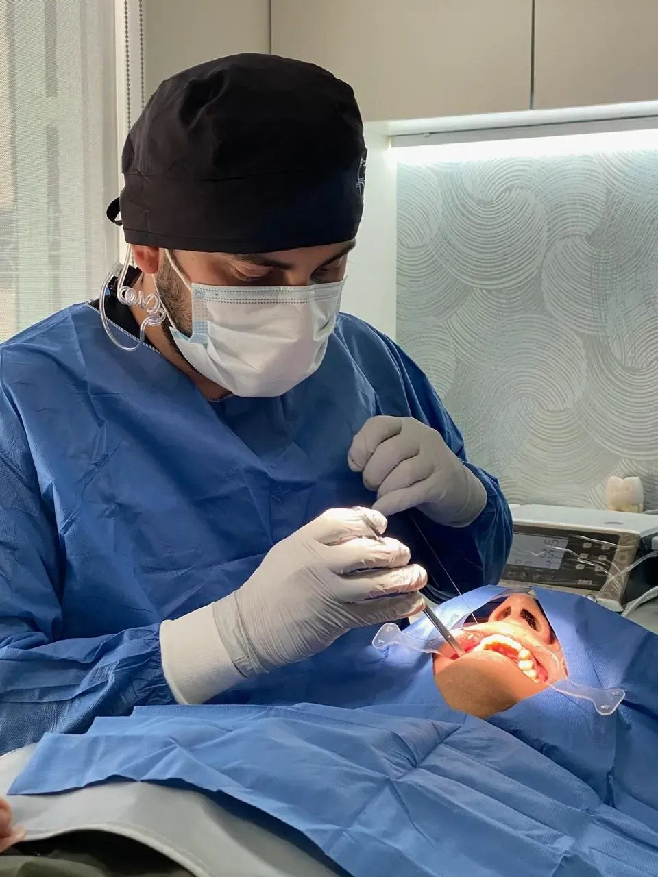 Profesional de Alta Estética Dental durante un procedimiento quirúrgico en el consultorio.