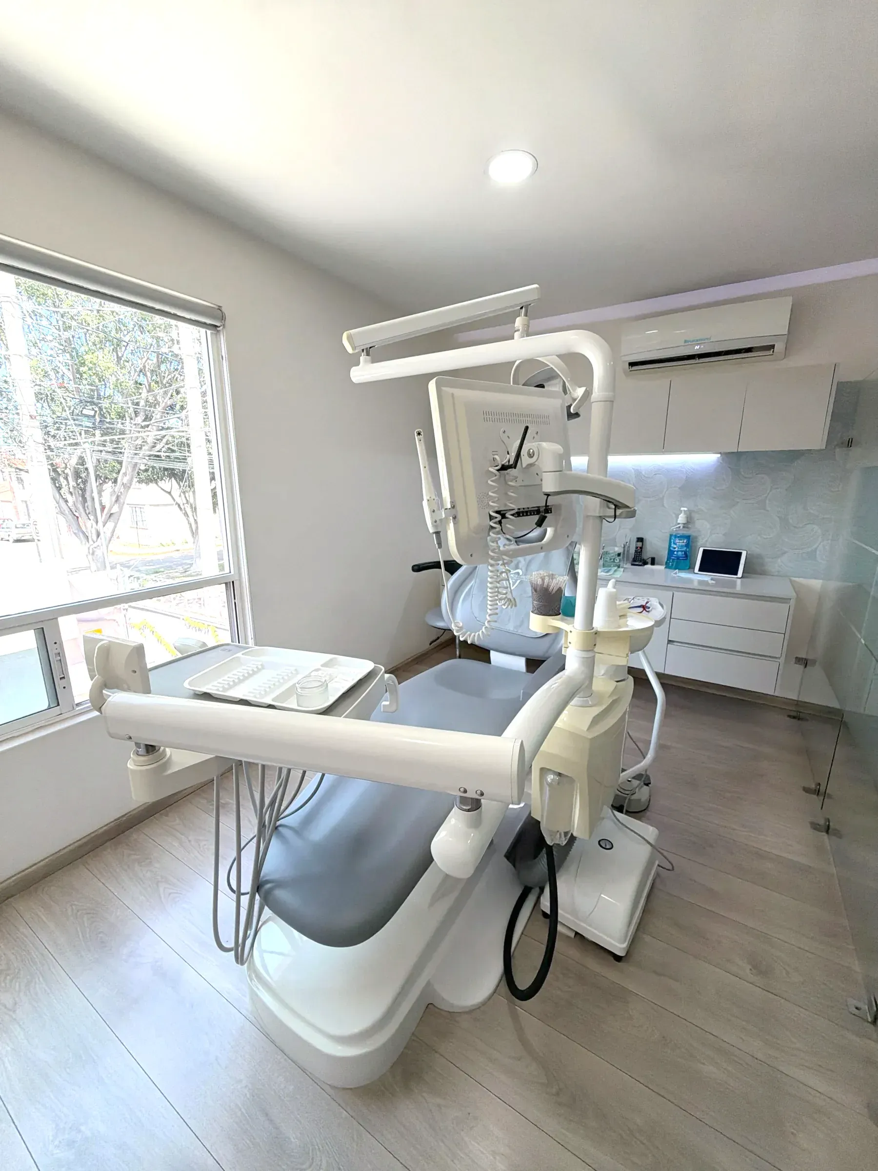 Consultorio de Alta Estética Dental con luz natural y el sillón preparado.