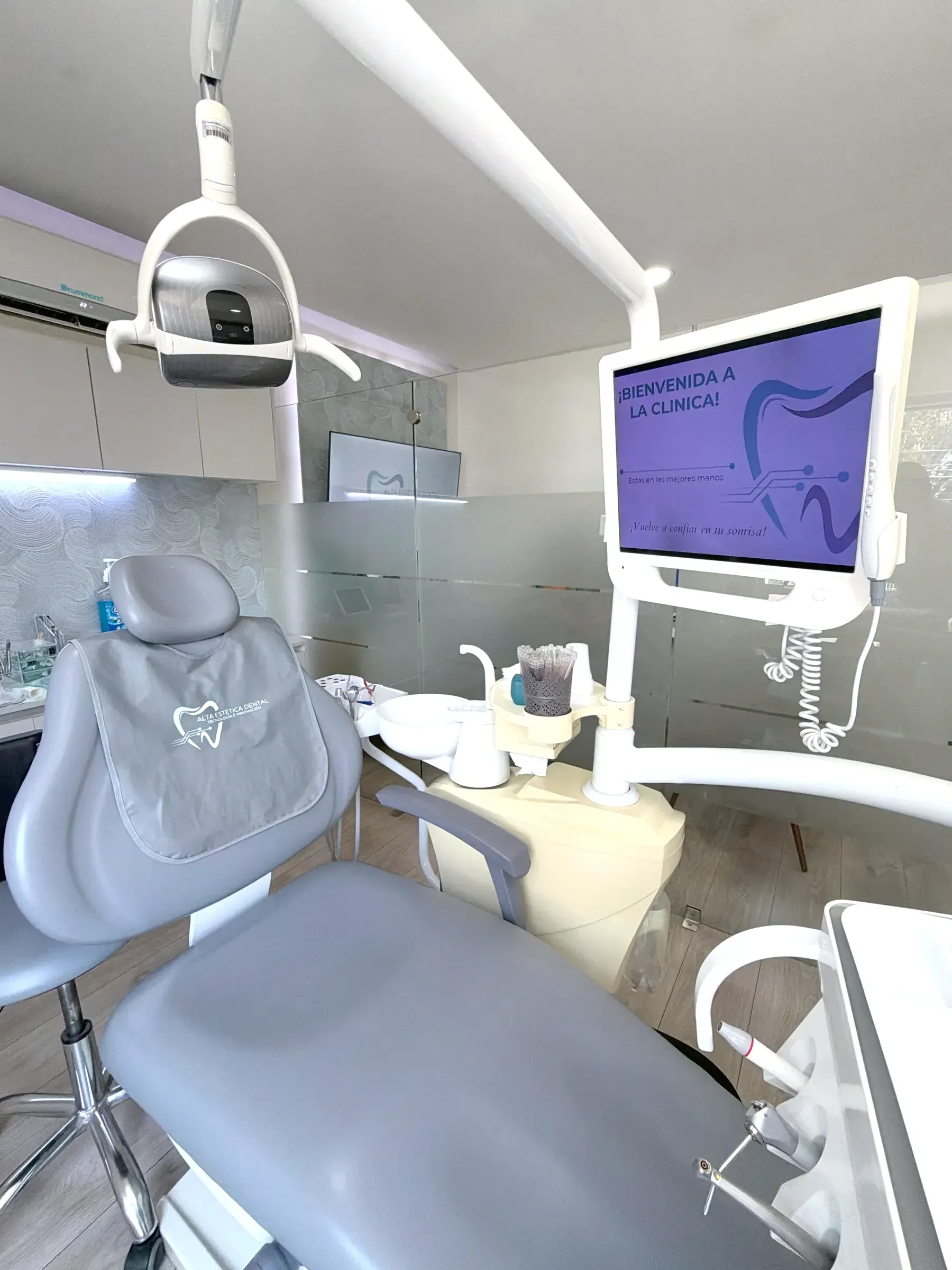 Consultorio de Alta Estética Dental con el sillón preparado y una pantalla que da la bienvenida a la clínica.