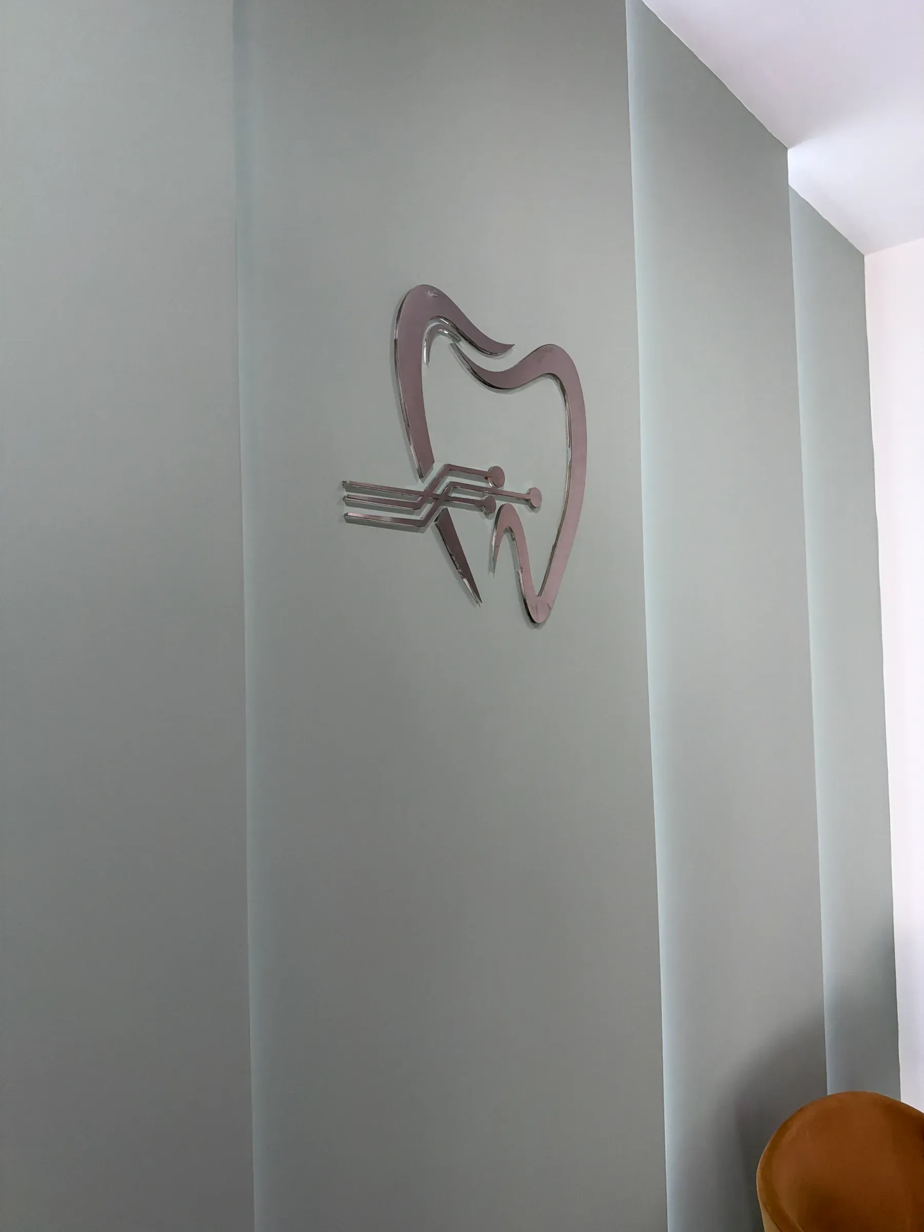 Emblema de la clínica en relieve sobre un panel de cristal esmerilado.