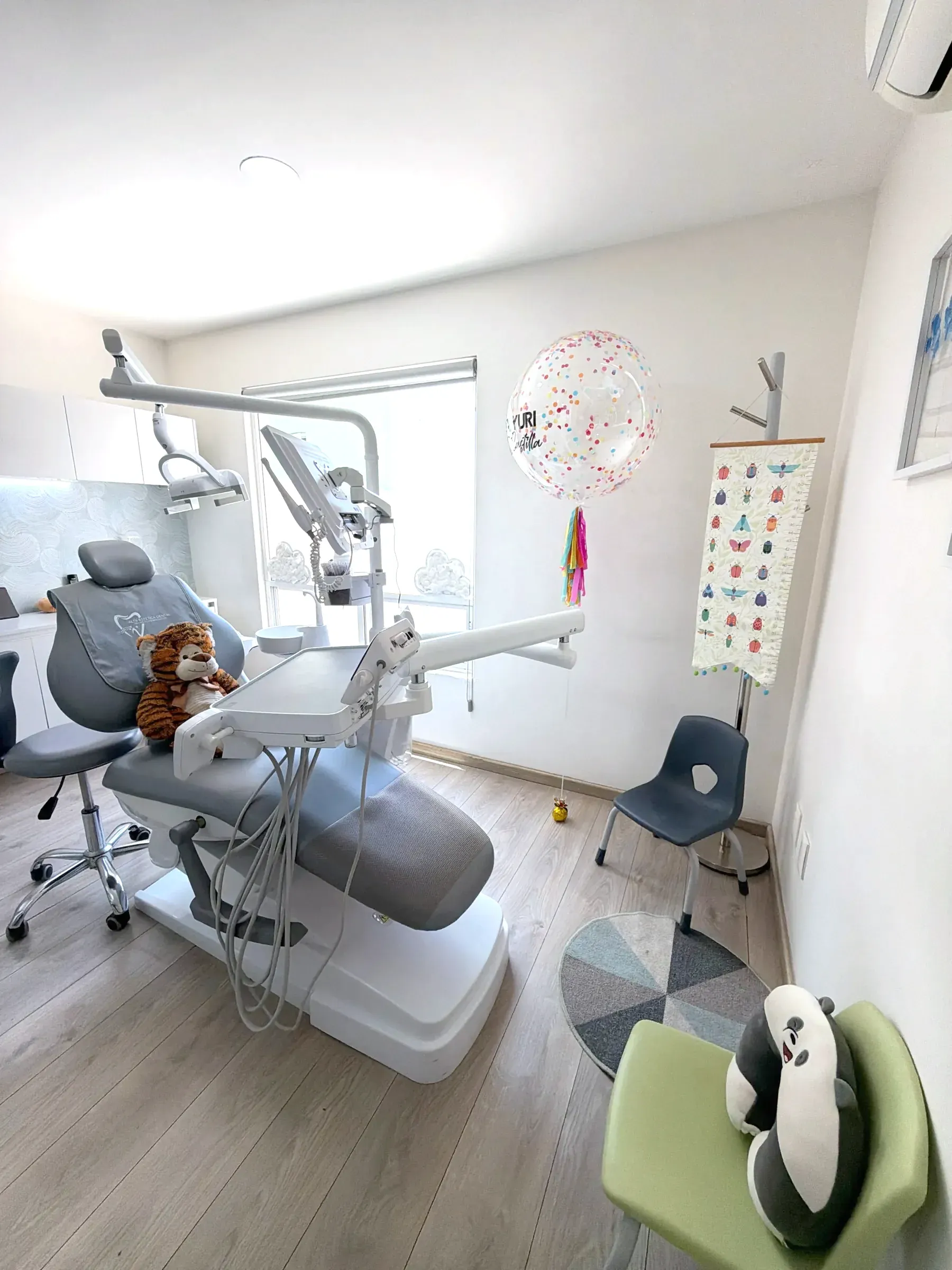 Consultorio de odontopediatría con peluches en el sillón y decoración infantil.
